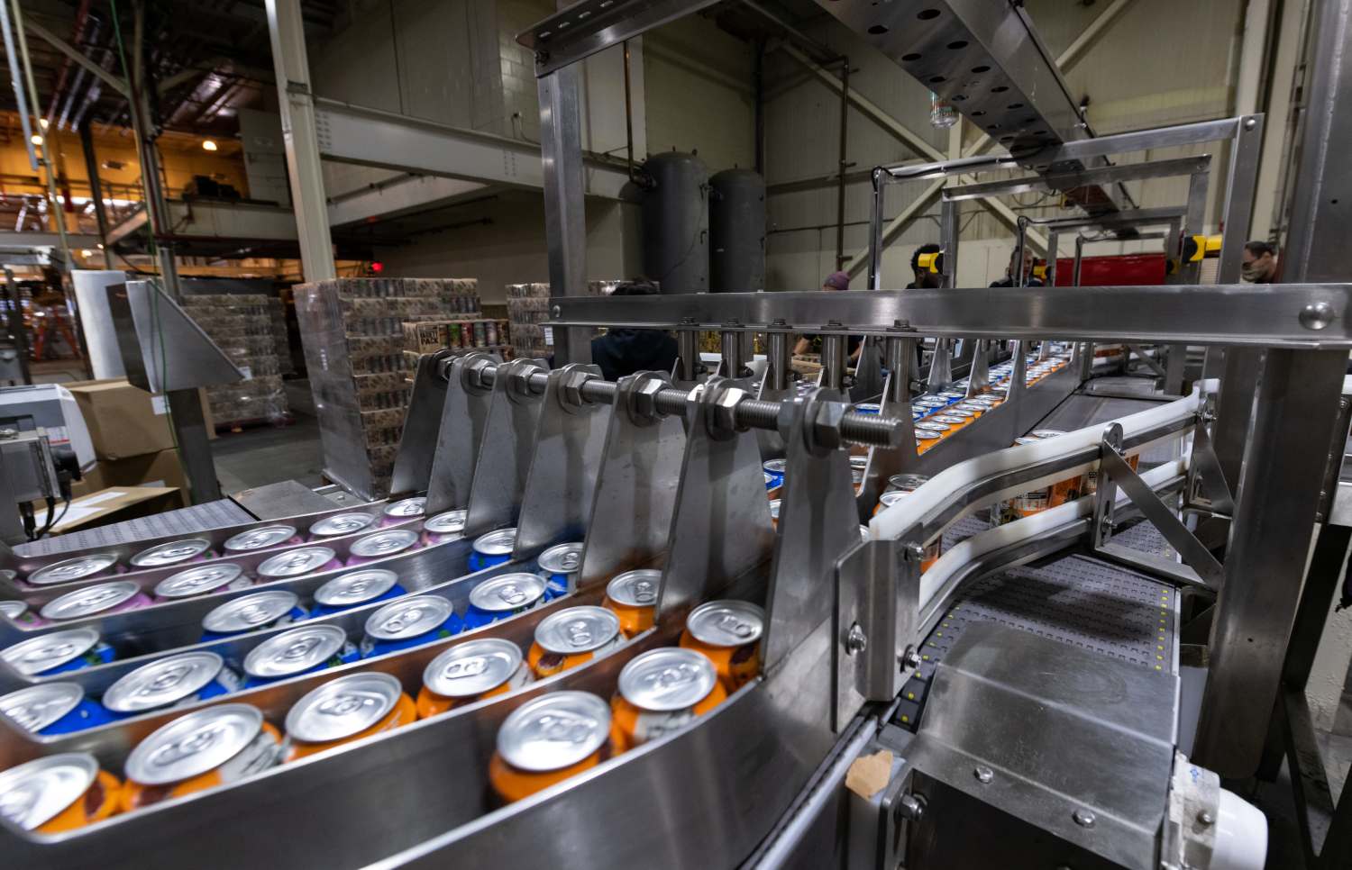 A Line of Canned Beverages on a Conveyor